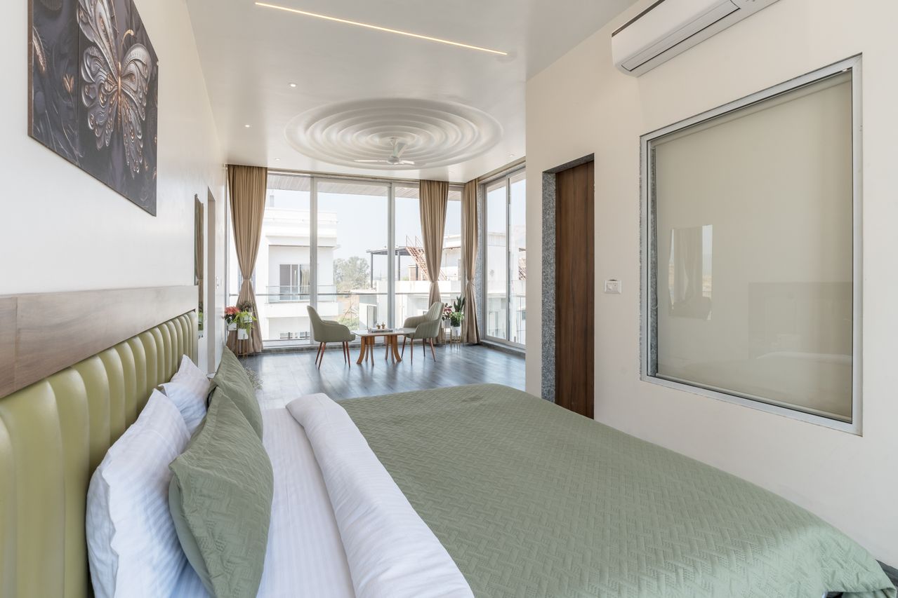 Sage suite with seating by floor-to-ceiling windows and dark wood floors