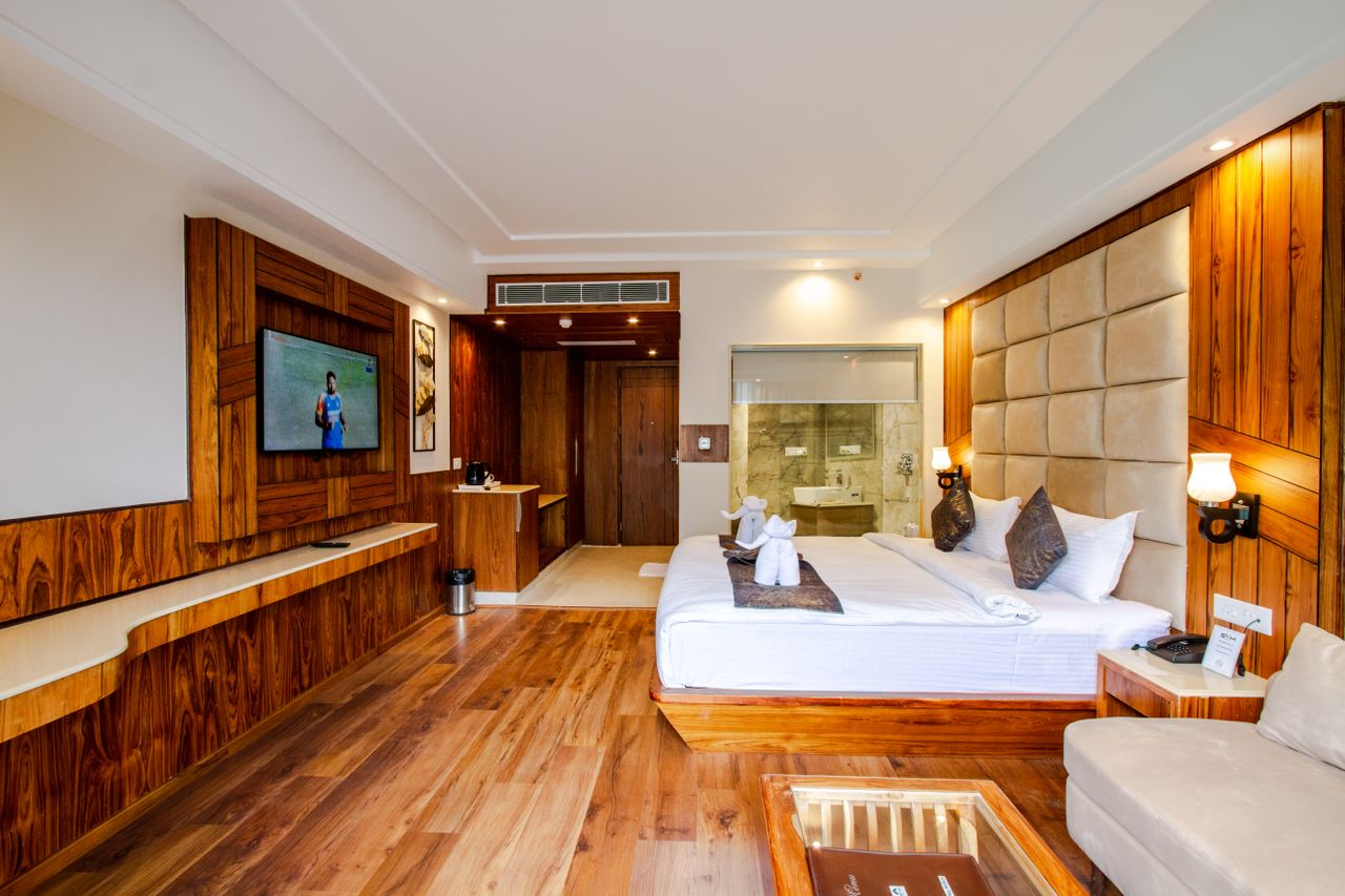 Wood-panelled suite with king bed, lounge corner, and adjoining bath