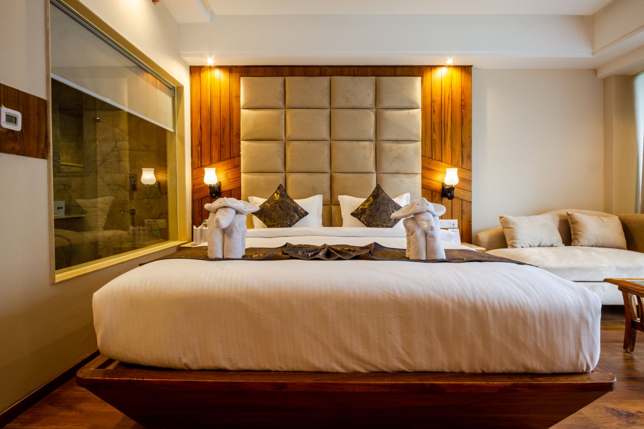 King bed with tufted headboard and wall lamps in a Brambleknollretreat suite