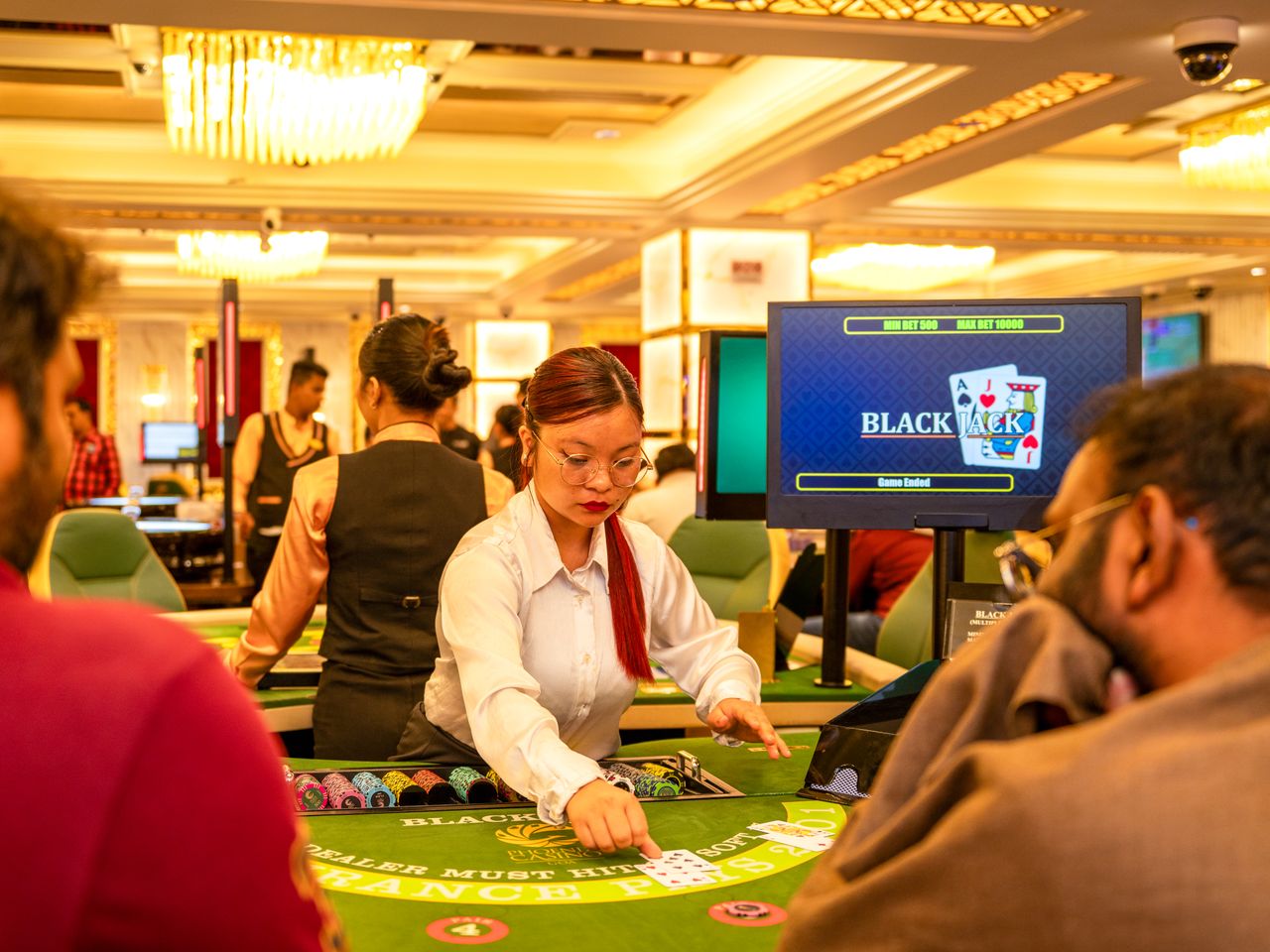 Profesjonell dealer ved et blackjackbord i kasinoloungen i Oslo